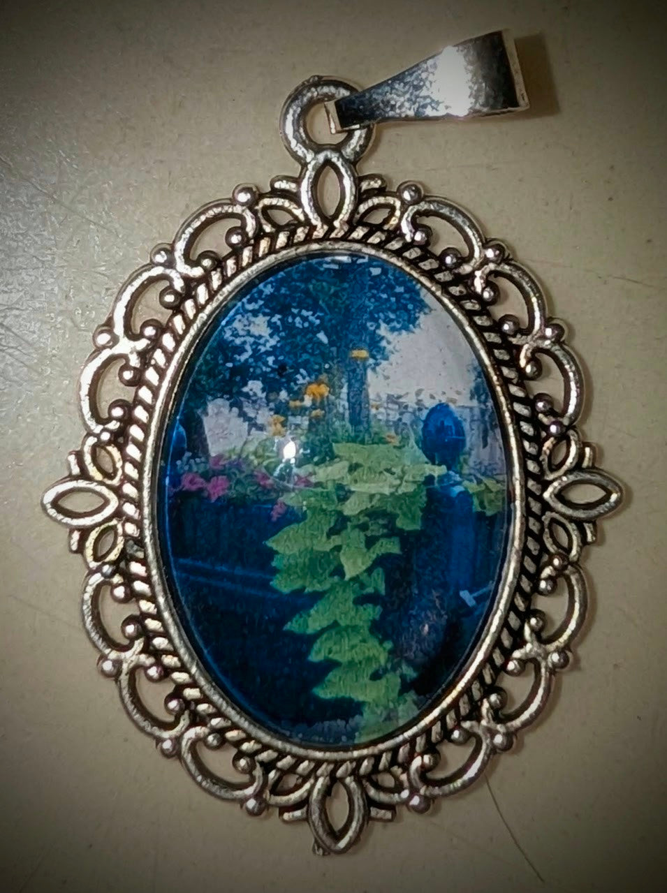 Macro photography pendant of a lush green garden planter with overflowing botanical details, set in a vintage-style decorative oval frame.